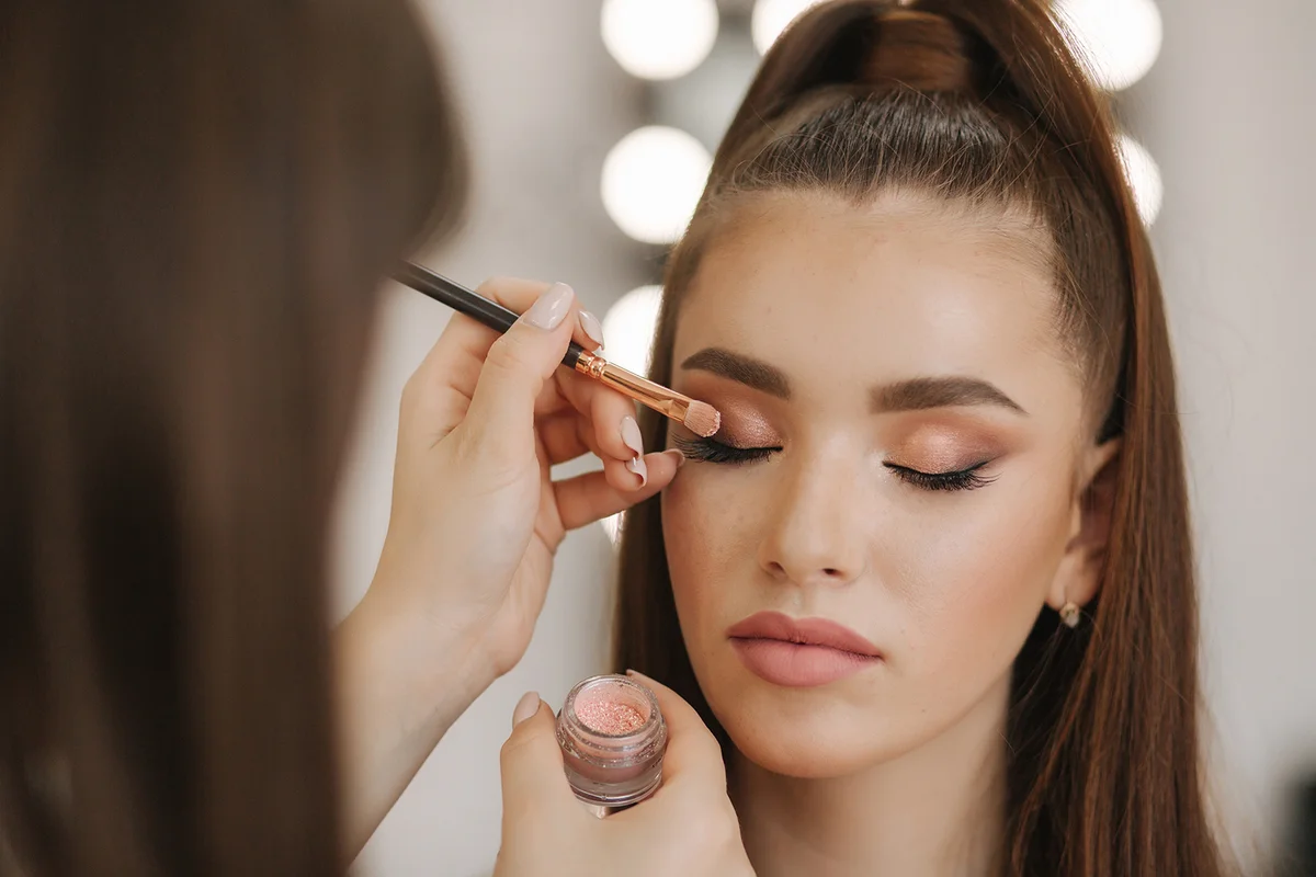Makeup artist applies eye shadow,