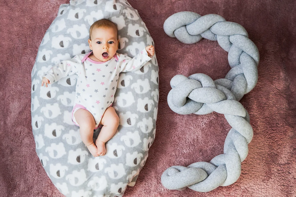 three month old baby girl relaxing on a pillow at home