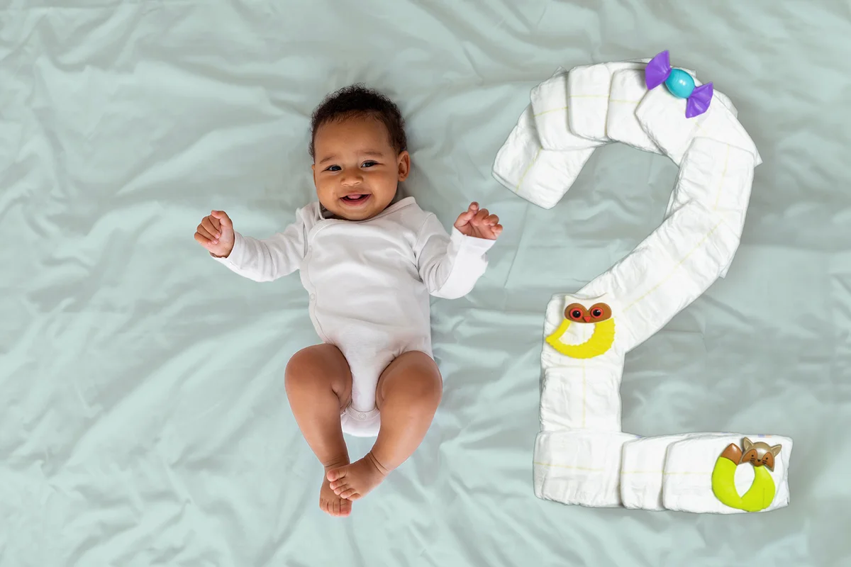 Portrait Of Cute Laughing Black Infant Baby Lying On Bed,