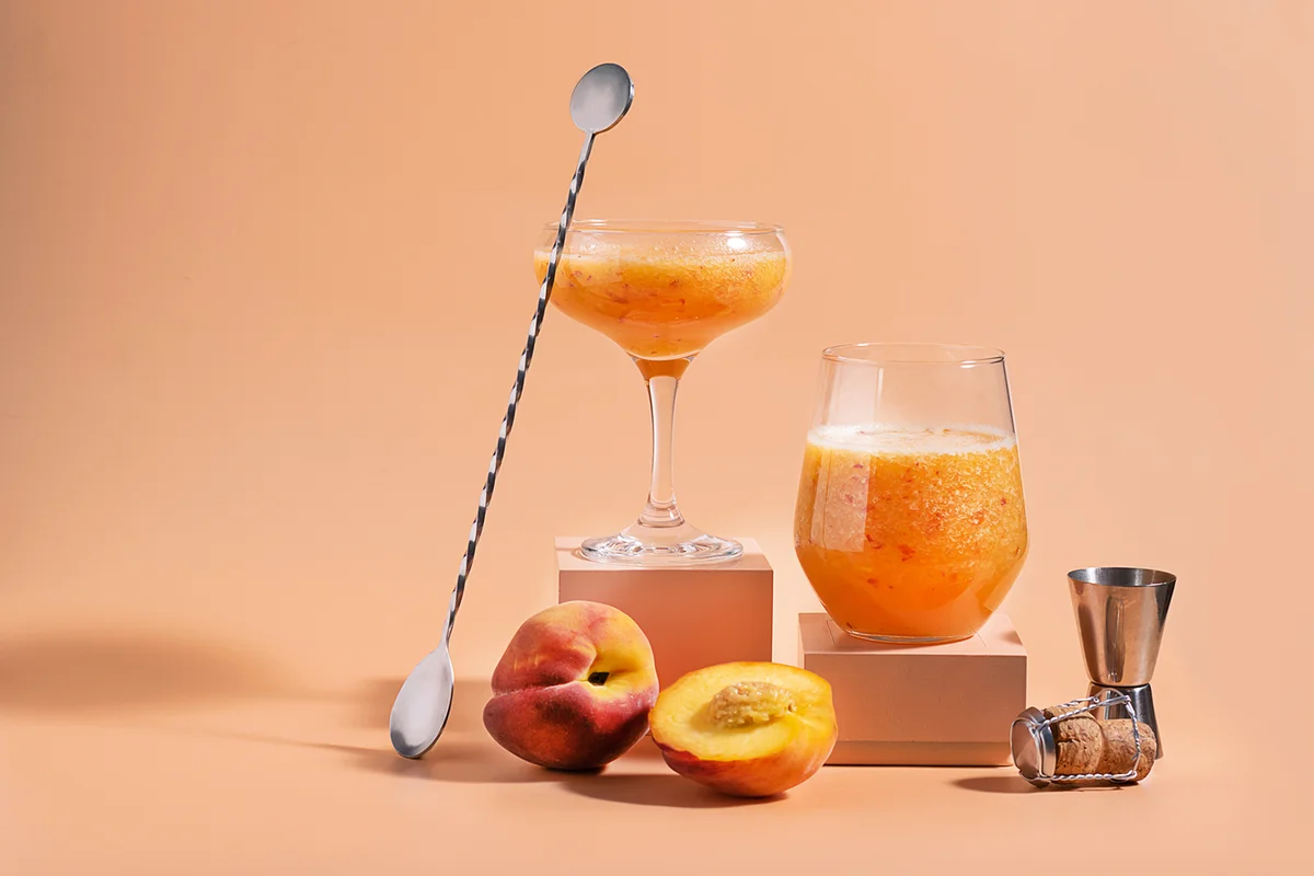Summer refreshing fruit cocktail bellini of fresh ripe peach and champagne