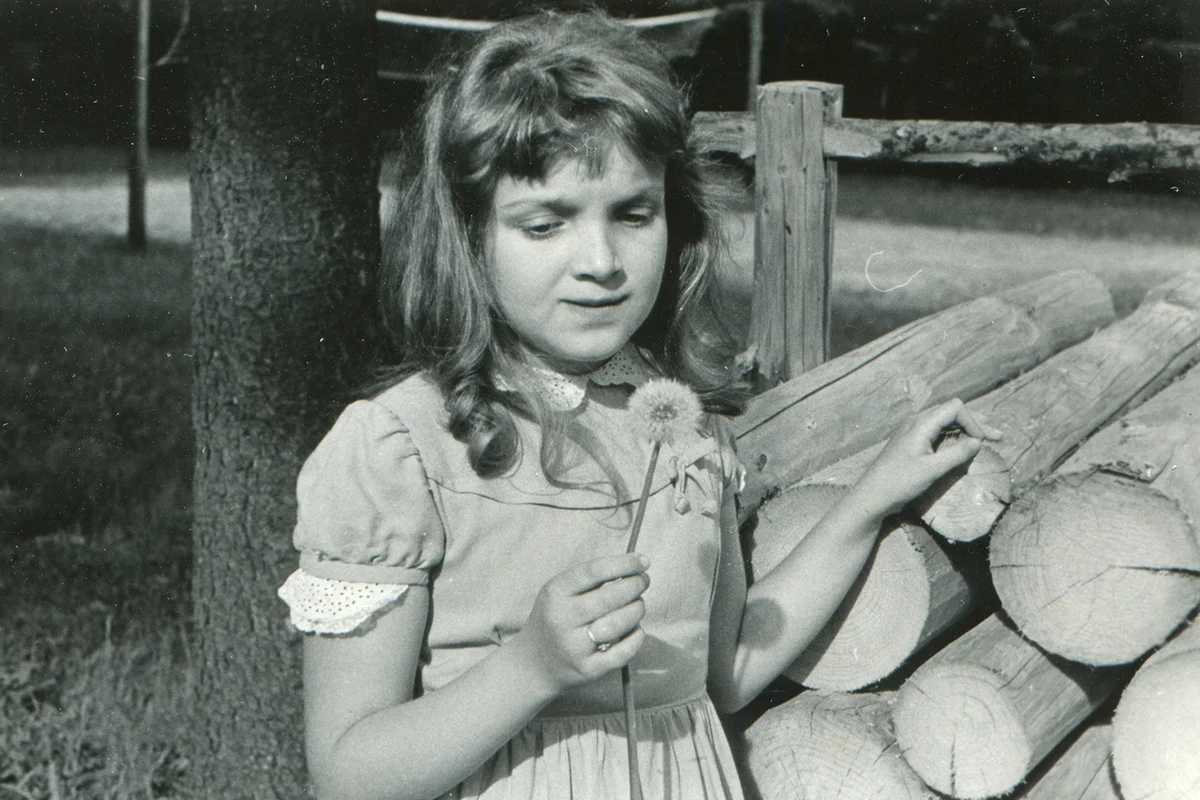 Vintage photo of young girl with a dandelion (fifties)