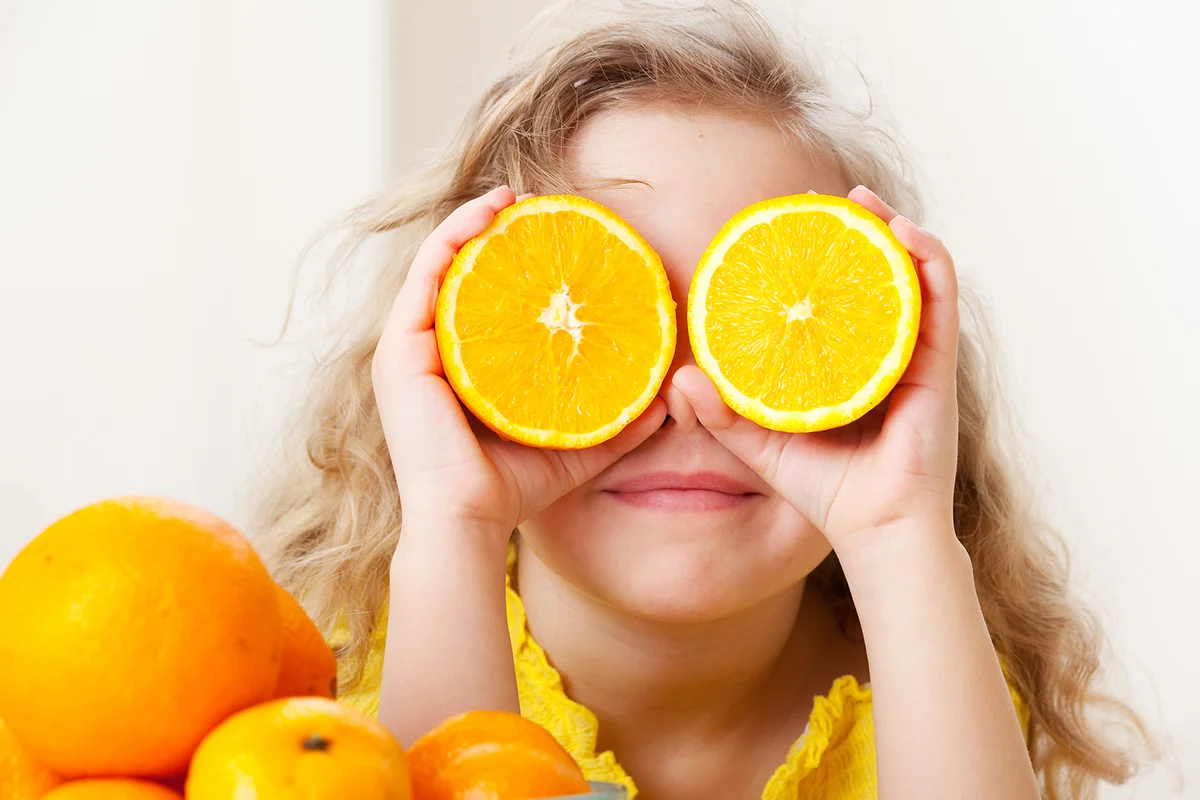 Happy little girl with fruit at home