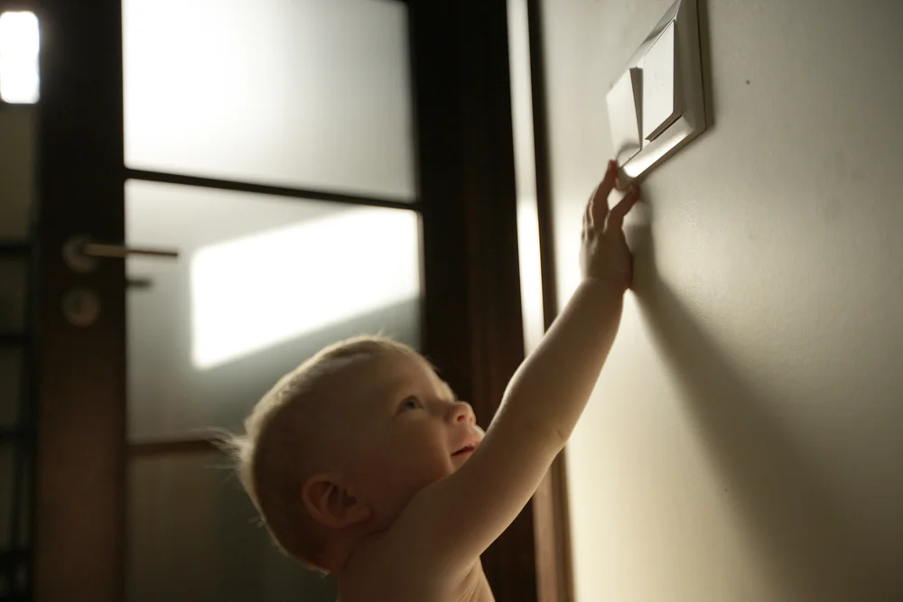 baby touching a light switch