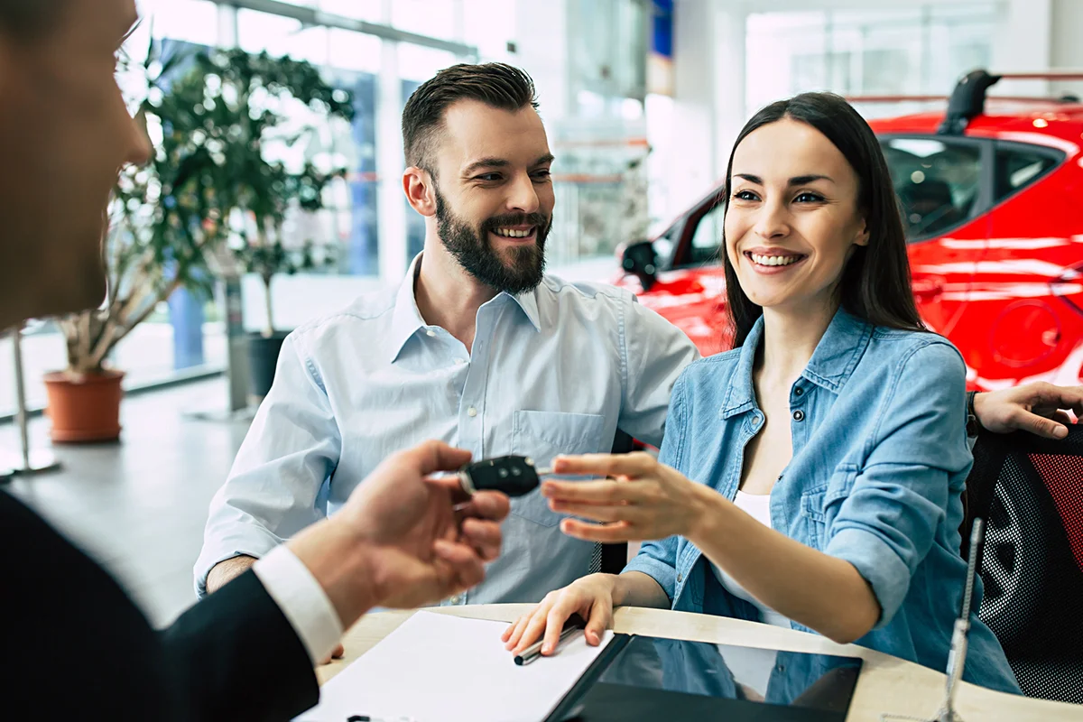 Beautiful happy couple bought a car in the dealership