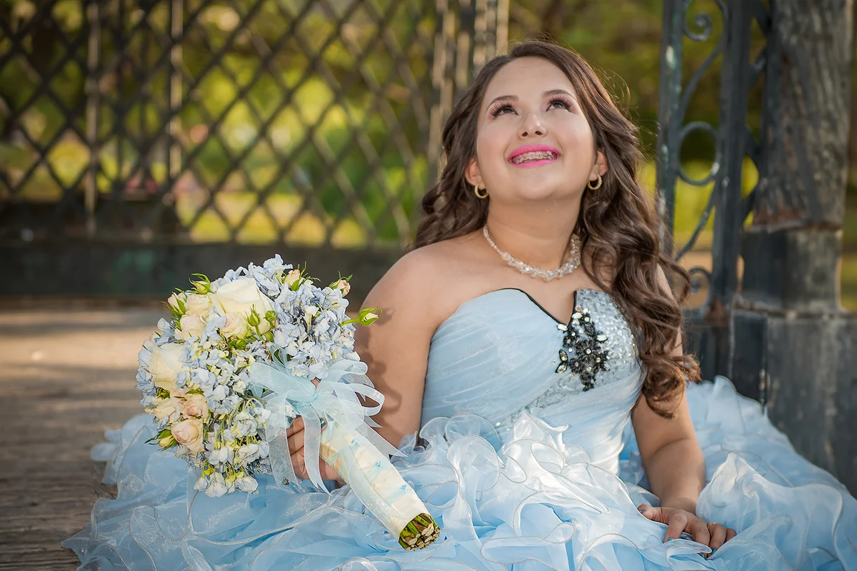 Quinceañera photography session in a beatiful steel arch in a park.