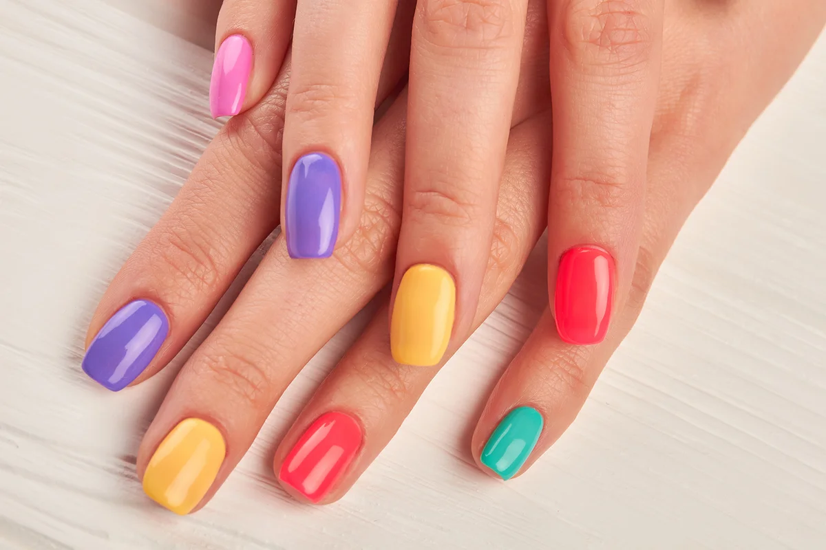 Female fingers with colorful nails.
