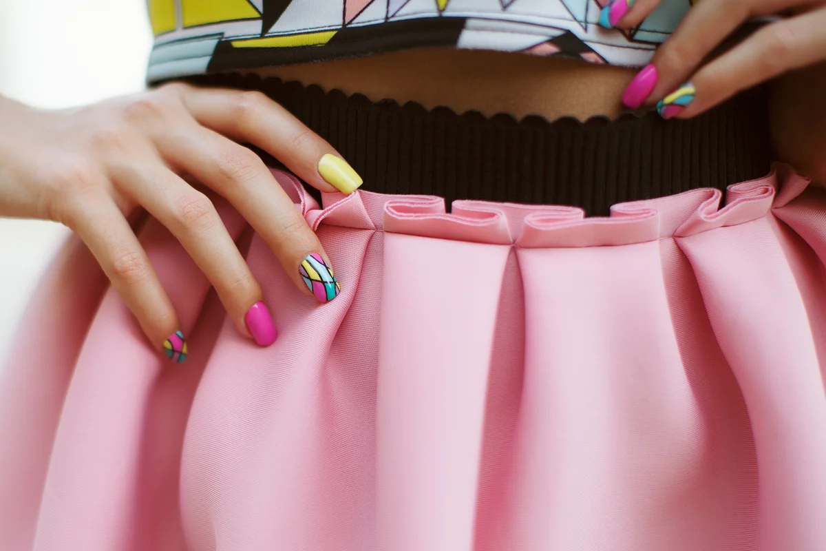 Fashion woman with pink skirt and neon manicure