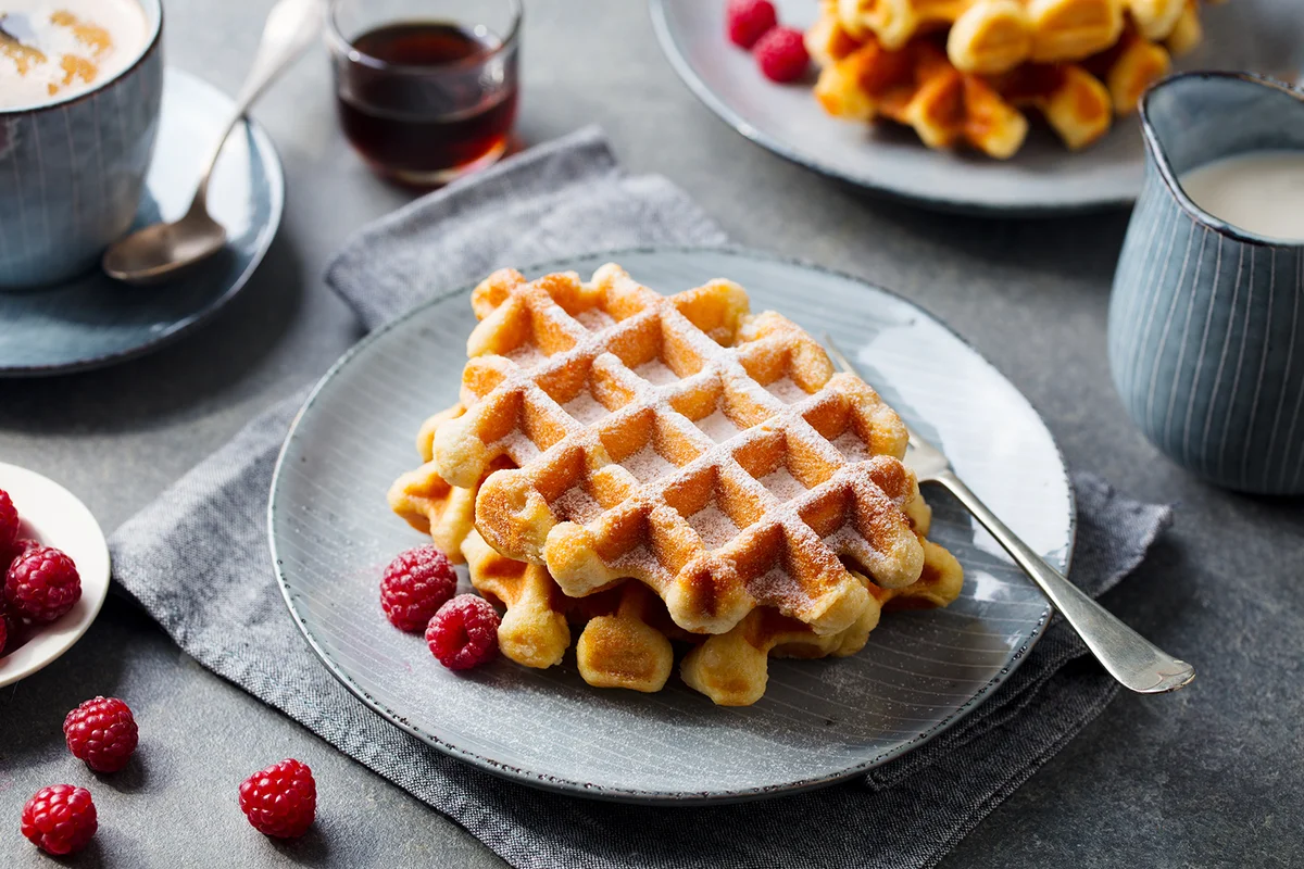 Breakfast Belgian waffles with maple syrup and fresh raspberry