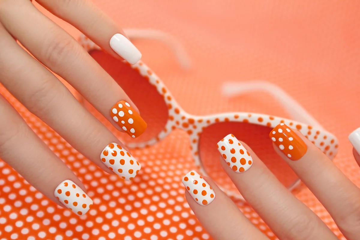 Sunny orange manicure with dots on the women's nails