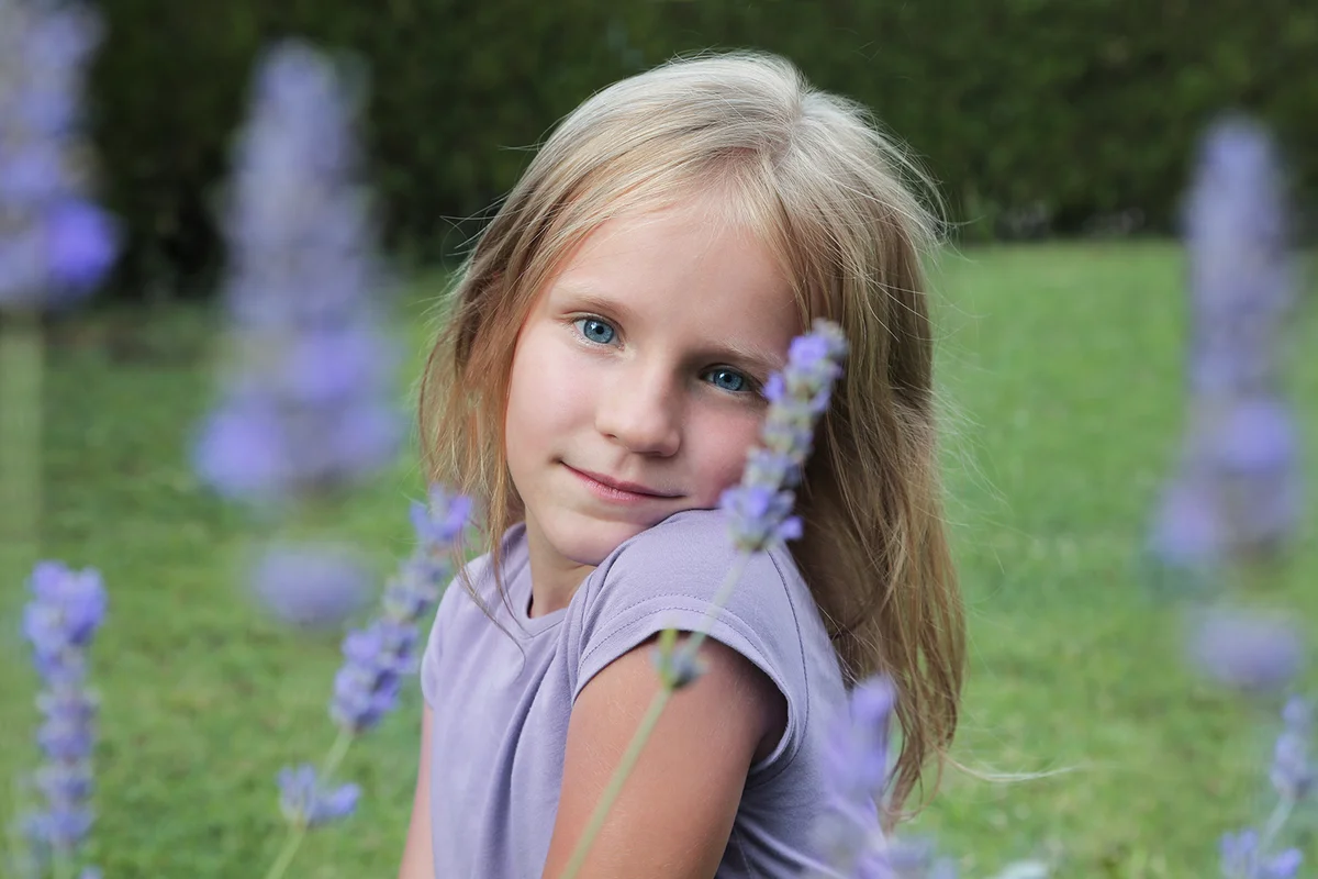 Beautiful smiling blond blue-eyed girl, portrait in a lavender flowers