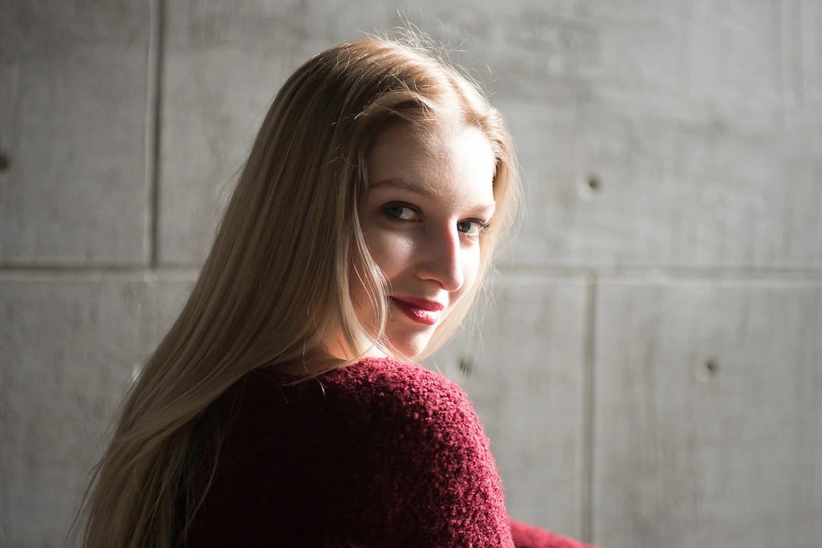 portrait of a young beautiful blonde in the studio, sits in a red sweater