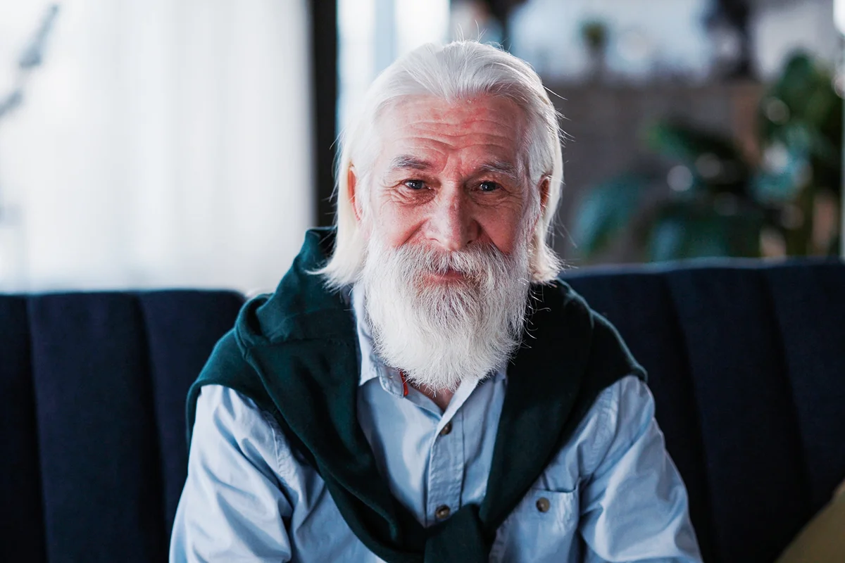 man with long beard loooking cheerful to camera smiling