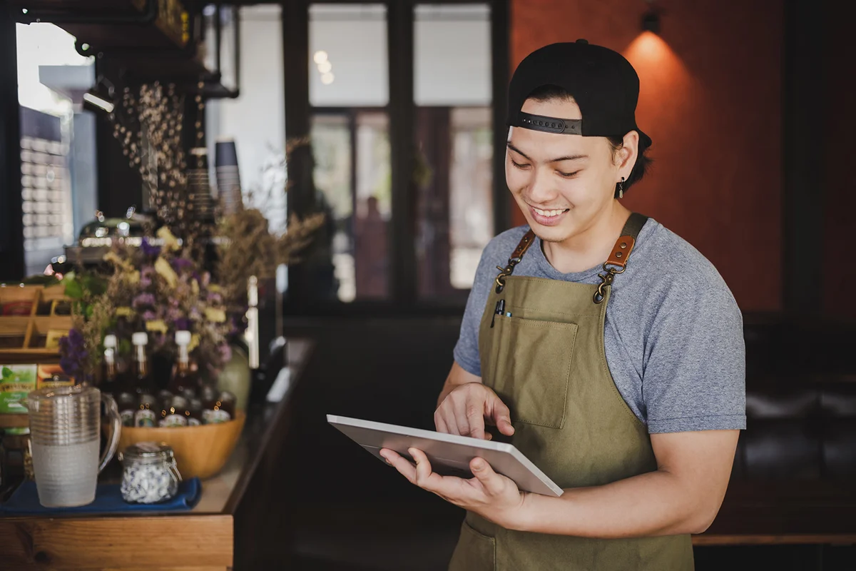 barista holding tablet for checking order from customer on coffee cafe