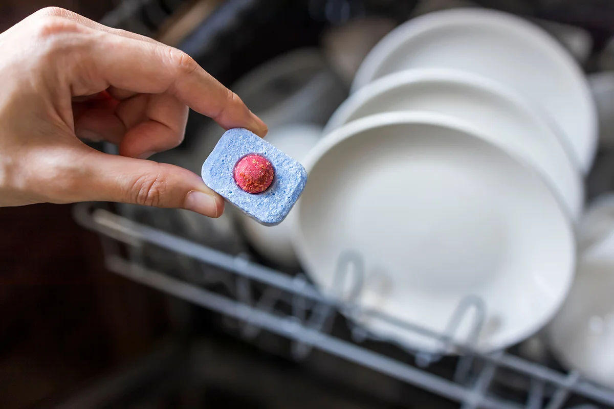 woman hand filling dishwasher tablet