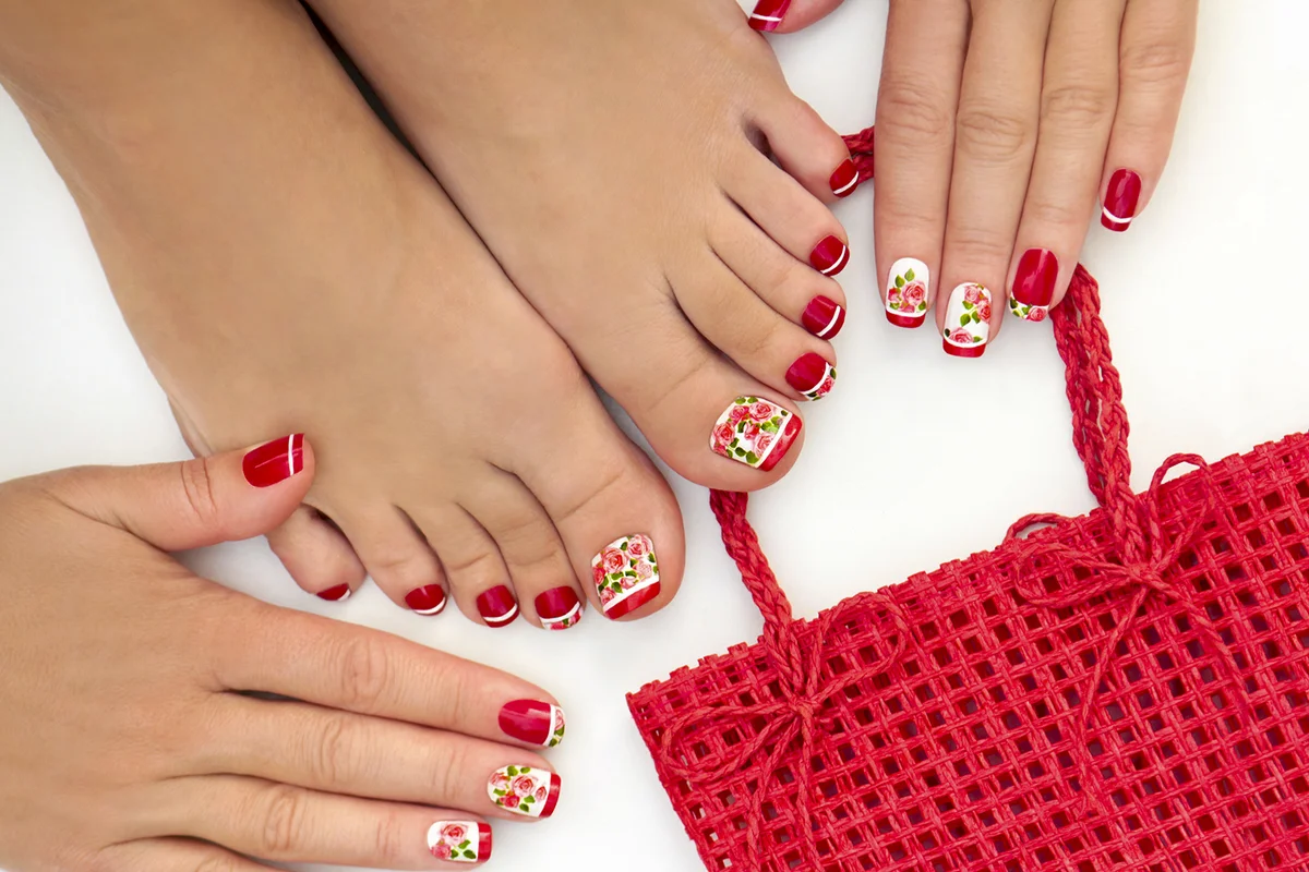 Red French manicure and pedicure with design of roses