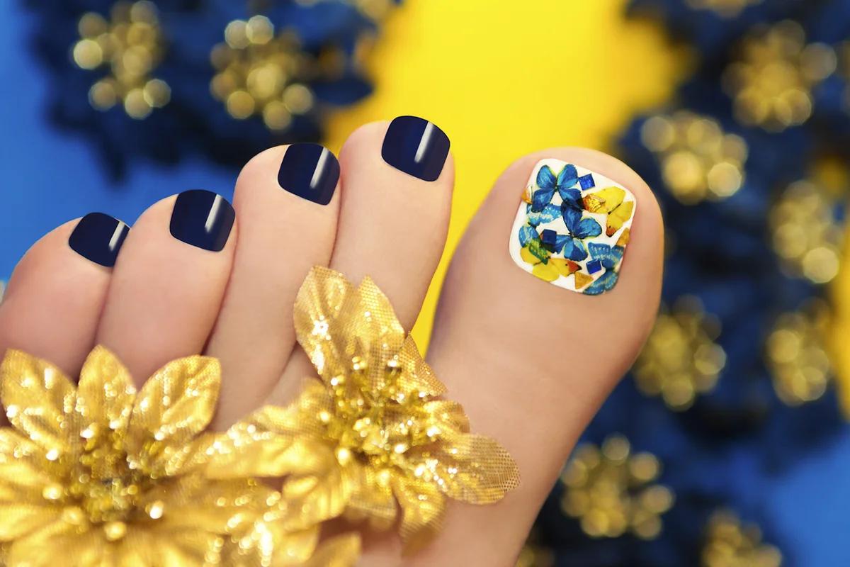 Blue pedicure with butterflies in white lacquer big toe with Golden flowers