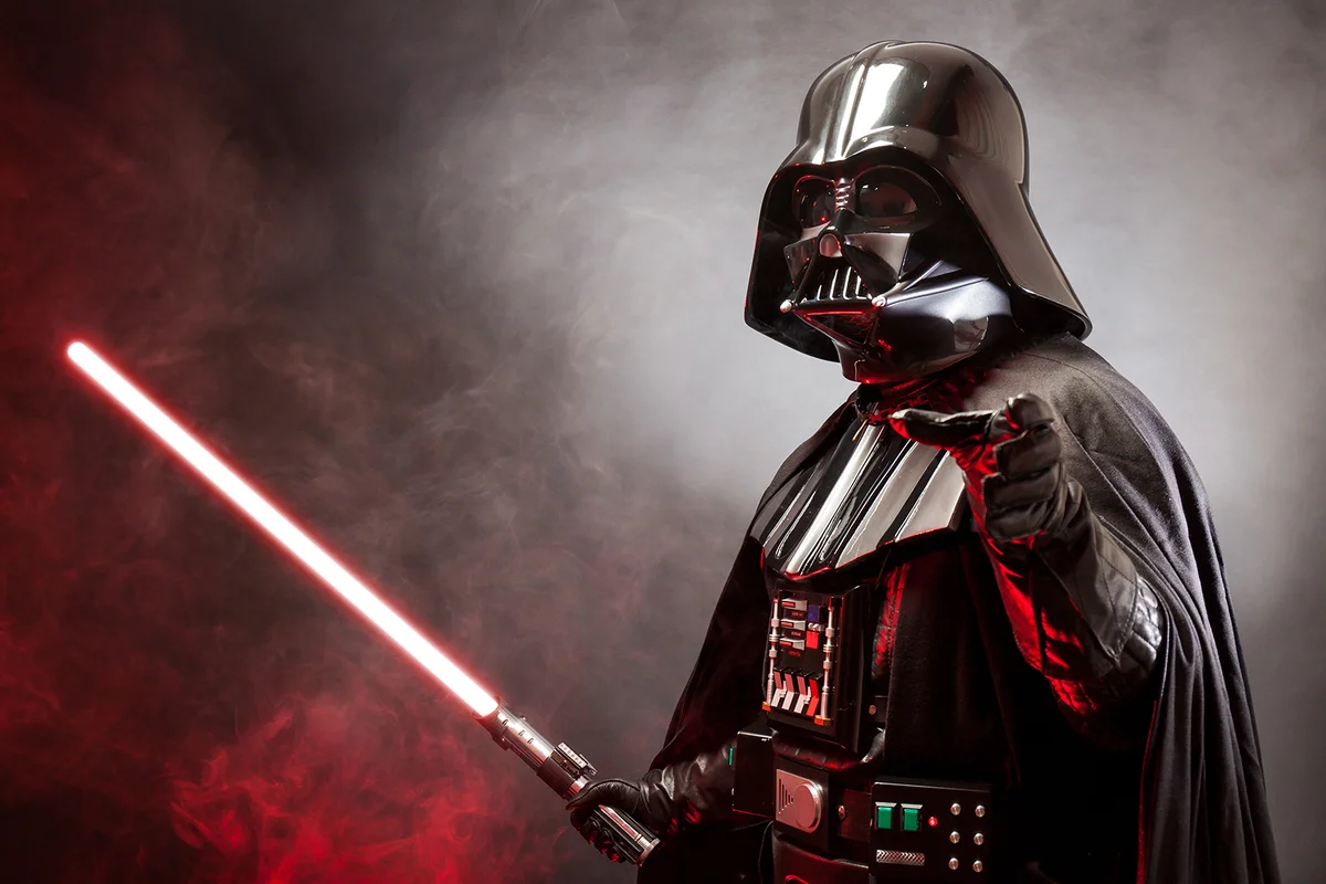 Portrait of Darth Vader costume replica with grab hand and his red sword.