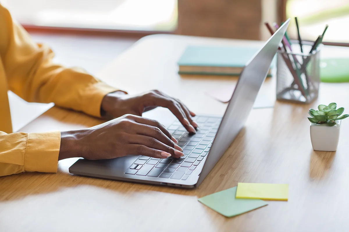 woman's hands typing on laptop