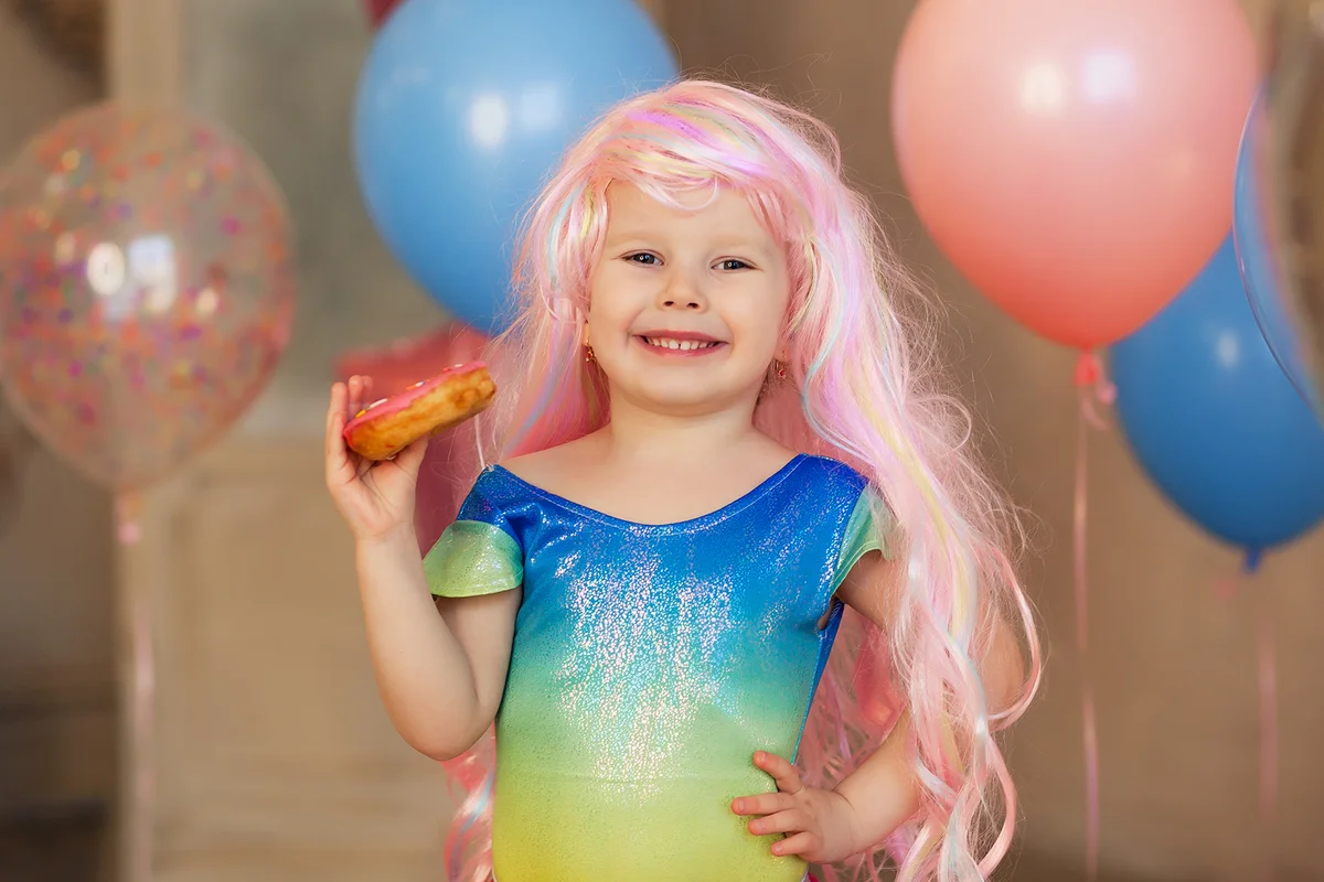 little happy girl 3-4 years old in a pink mermaid wig smiling,