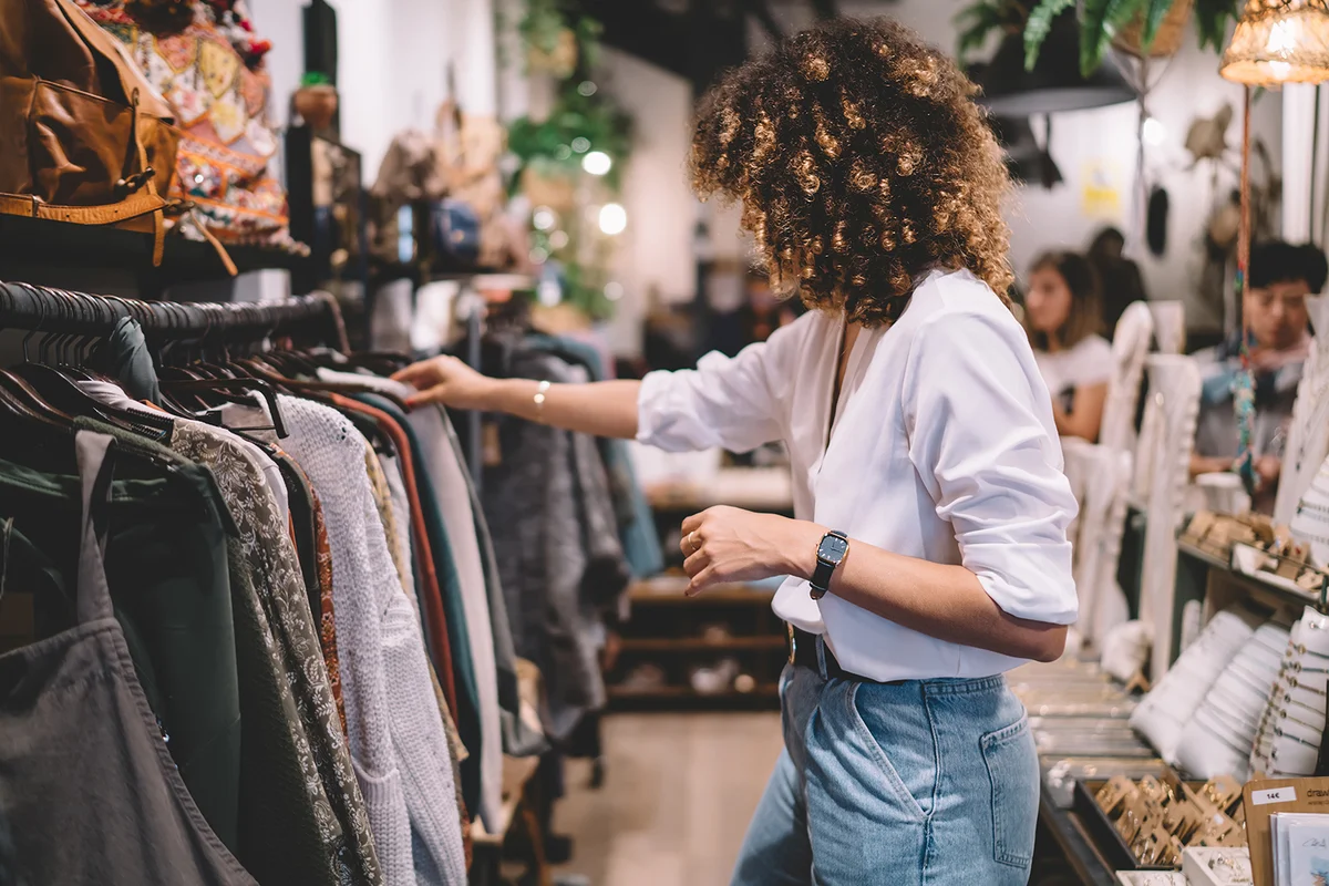 female customer with curly hair buying clothes