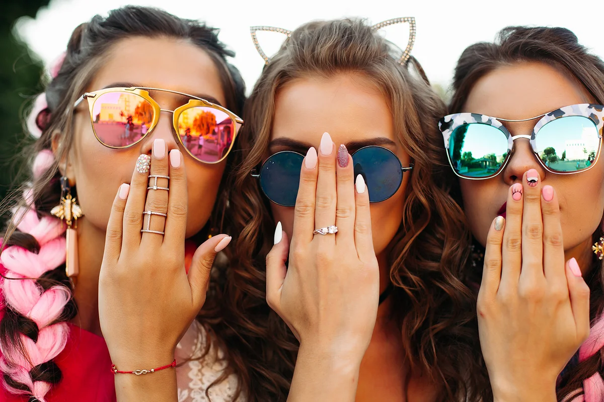 Close up of three young girls wearing in creative sunglasses with designed manicure