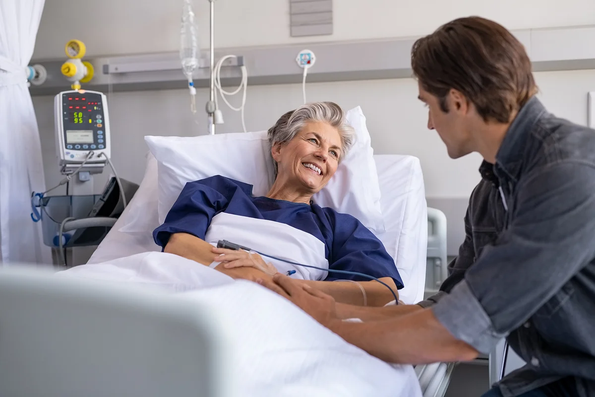 Son visiting sick old mother in hospital
