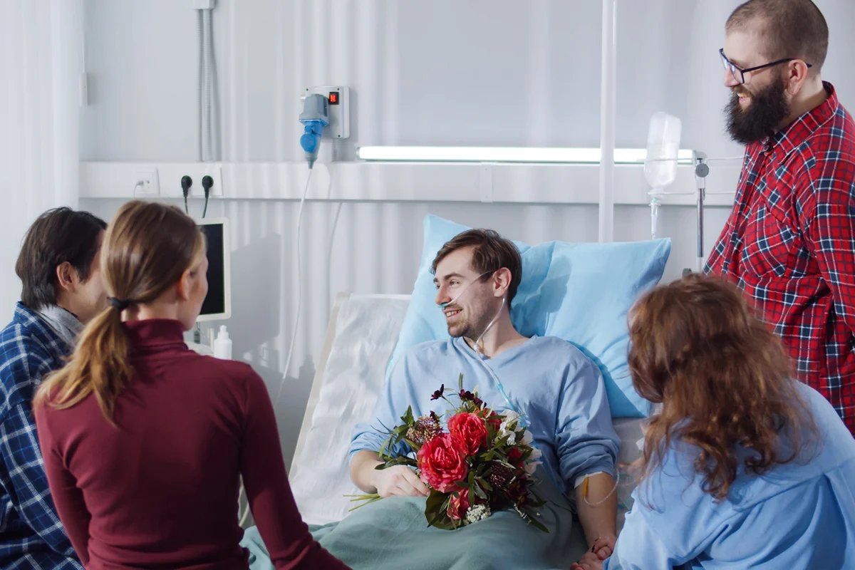 people visiting friend in hospital and bringing flowers