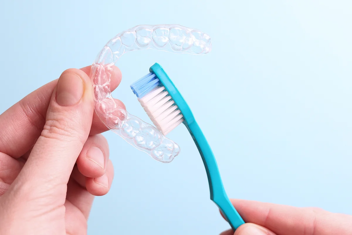 Cleaning plastic aligner aligners with a toothbrush