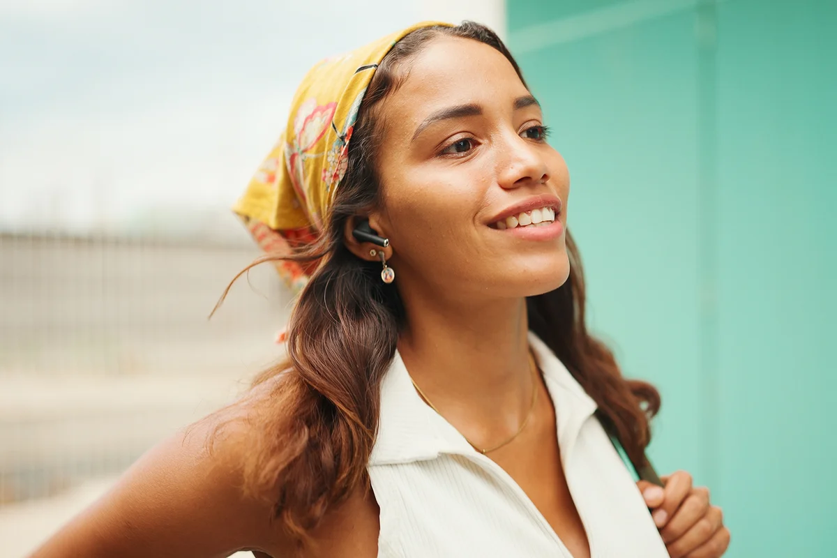 Beautiful girl with long hair wearing bandana and wireless headphones.