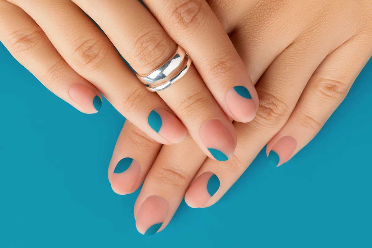 Close up womans hands with summer manicure on blue background.