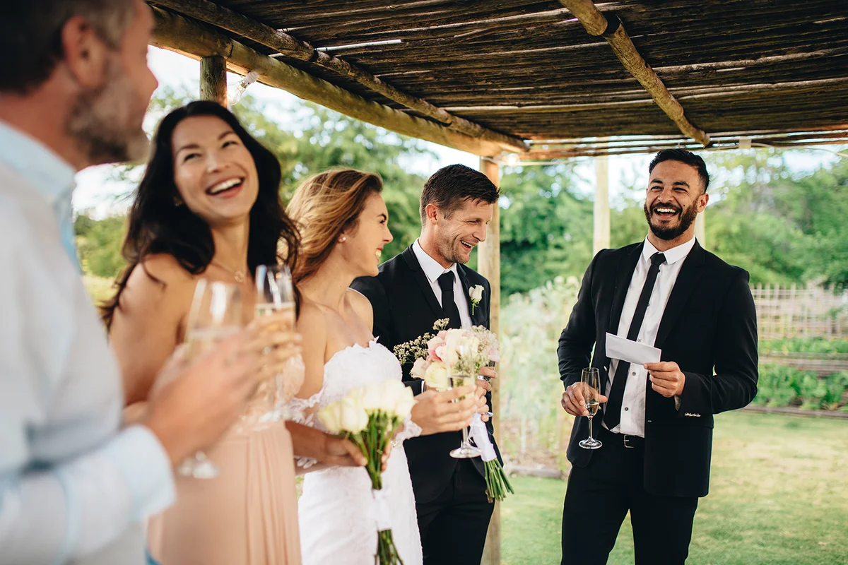 Best man giving speech to newlywed couple at wedding reception