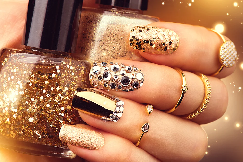 Close-up of nails with an embellished gold manicure