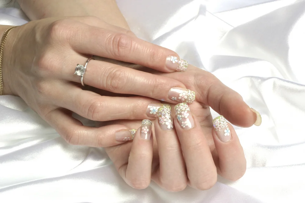 Close-up of transparent manicure with flower stickers