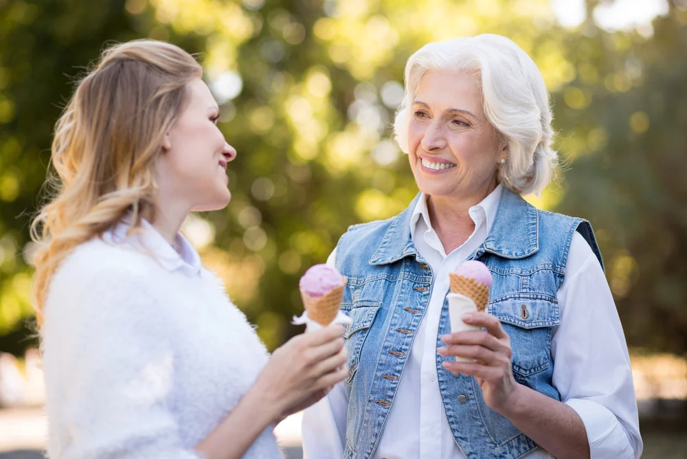 Smiley woman having ice cream with her mother in the park