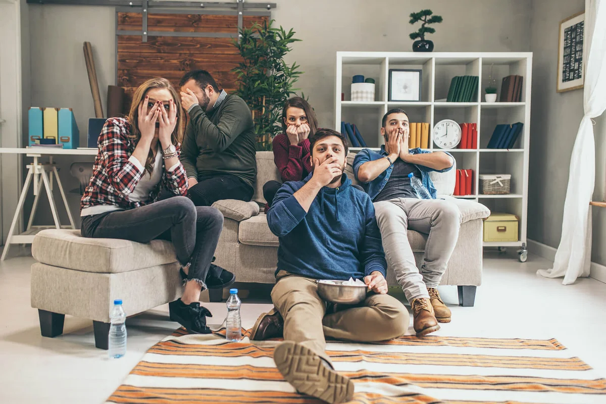 Group of friends watching scary movie
