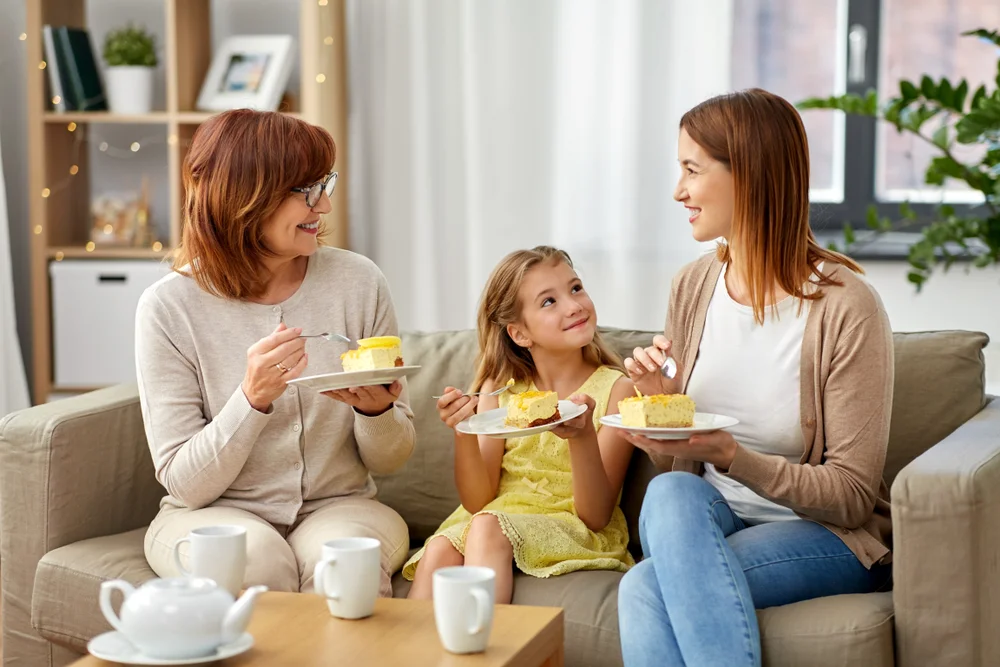 Smiling mother, daughter, and grandmother having a tea party