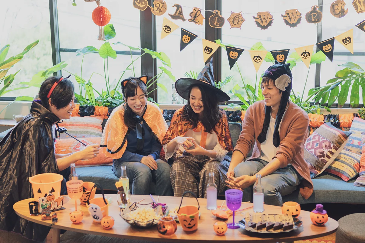Young group having a Halloween party and playing a game around a table