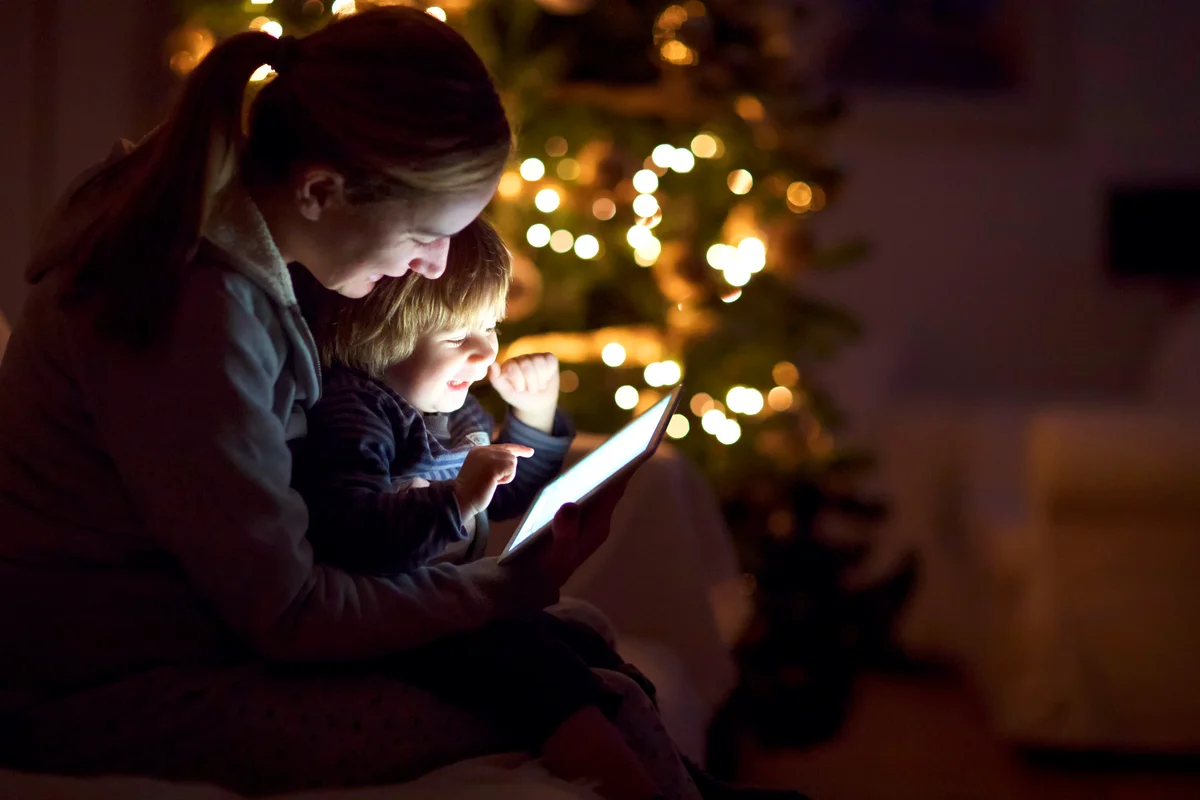 Mother with his son looking a digital tablet in the dark
