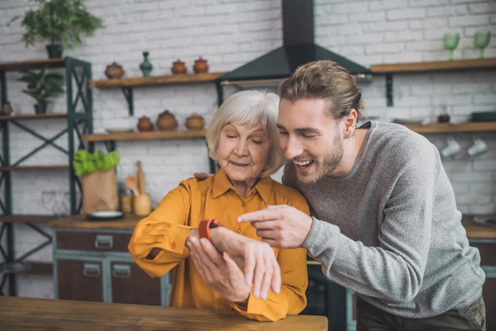 Lady in yellow feeling great with her son trying out a new smartwatch