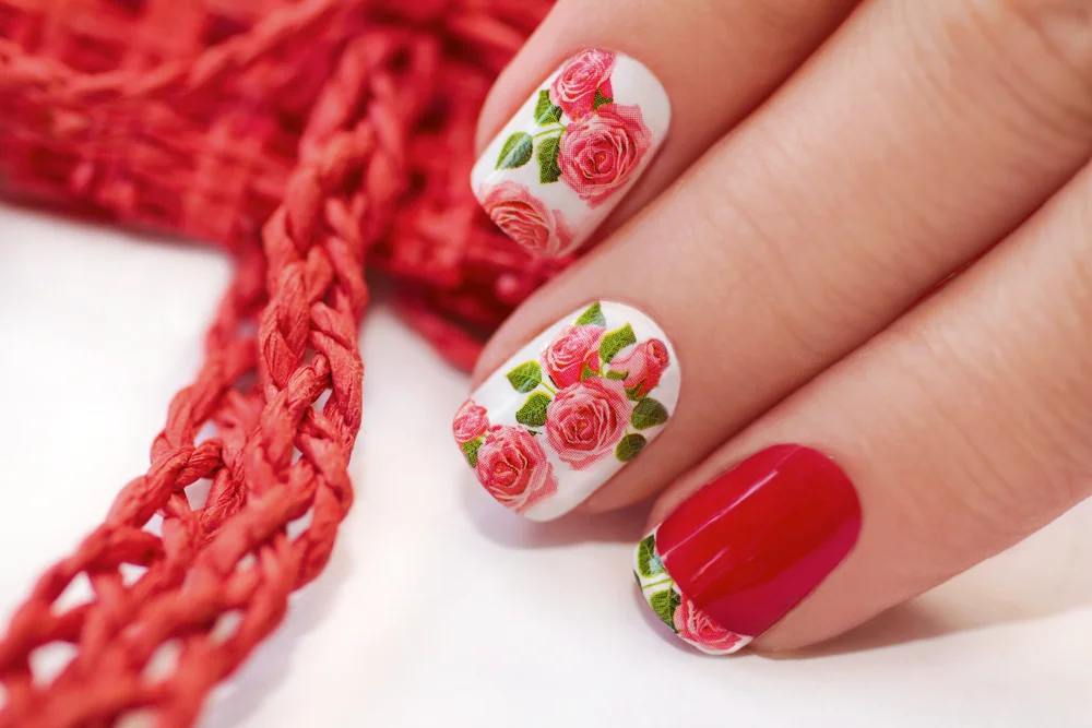 Red French manicure with a design of roses on a white background