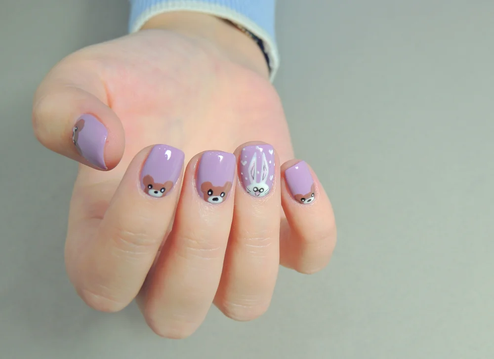 Cute lavender manicure on short nails with little bunny and bear designs.