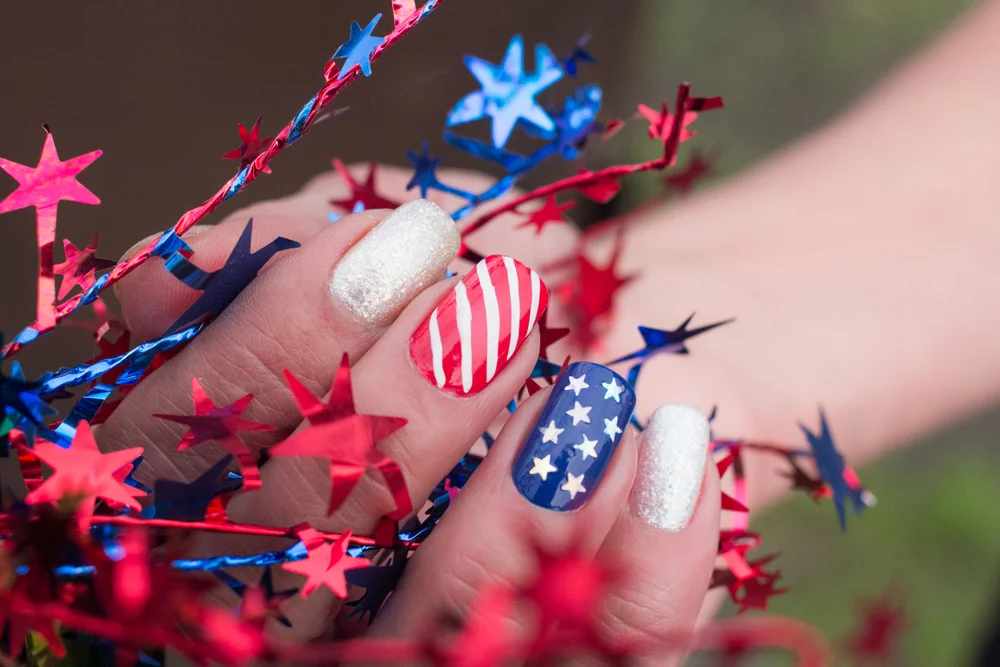 Close-up of a patriotic blue and red manicure US with stars and stripes on nails