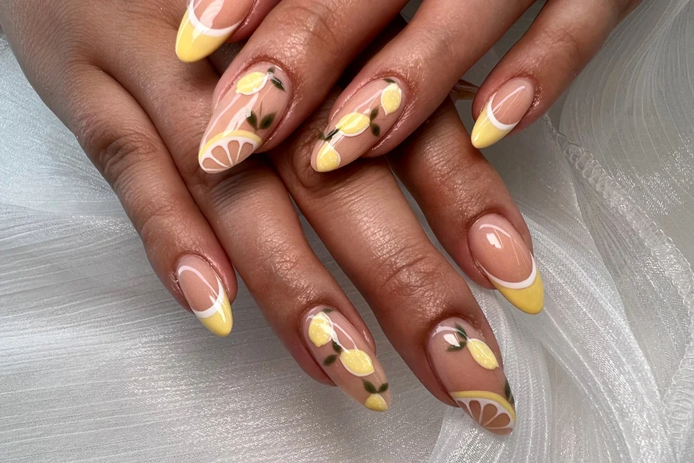 Close-up of nails with a cute little lemons nude and yellow manicure