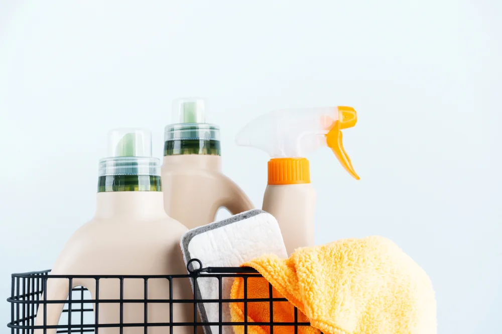 Сlose-up of spray and cleaning products in a metal basket on a white background