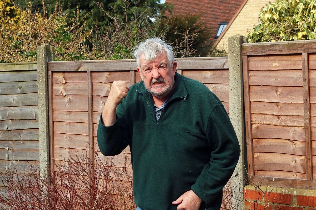 Angry old man shaking his fist and shouting.