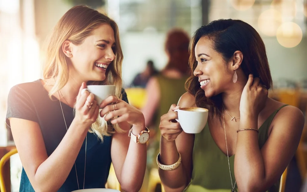 Two girlfriends talking and having a good time at a cafe