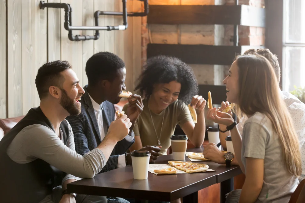 Multiracial cheerful people enjoying a meal together at restaurant