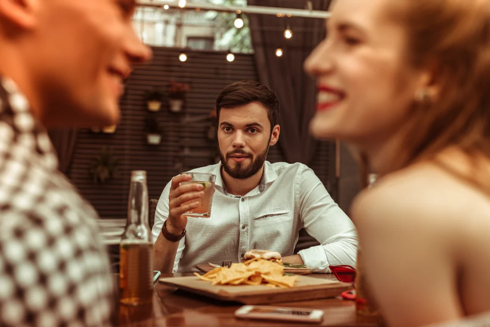 Jealous Taurus man watching a woman talk to a guy.