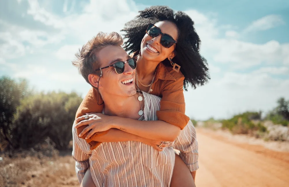 Taurus man romantically piggybacking a woman outdoors
