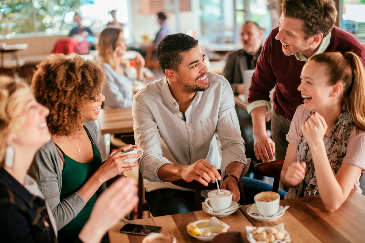 Group of young and diverse friends having coffee together in a cafe or bar